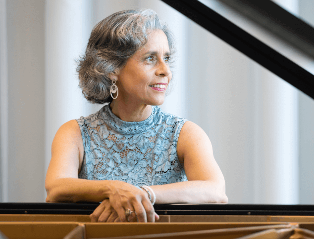 Konzertpianistin Marian Rosenfeld lehnt am Klavier